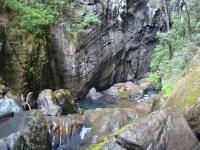 Vista do rio Maximiano no local onde ele adentra a caverna com as águas rápidas, turbulentas, barulhentas e atulhadas de grandes matacões desprendidos do alto paredão escarpado. Um belo cenário, um tanto assustador. Foto Antonio Theodorovicz