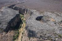 Vale do Rio Jacaré/Romão Gramacho, a jusante da gruta, pois o rio desaparece entre as rochas e aparece novamente no interior da caverna. Foto: Aloisio Cardoso, em Rocha e Pedreira, 2012.