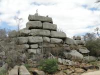 Visão panorâmica do geossítio Sacas de Lã, que se caracteriza como um inselberg do tipo Castle Koppie, apresentando ordem de fraturas ortogonais NS e EW e juntas de alívio / diaclasamento encaixados em estrutura tipo riacho-fenda (falha transcorrente NNE). Foto: Rogério Valença Ferreira.