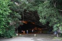 Vista da entrada do geossítio Furna de Sombrio que conta com sistema de iluminação interna e com estacionamento para os visitantes. No detalhe, a vista do interior da furna. (Autor: Michel Godoy/2011)